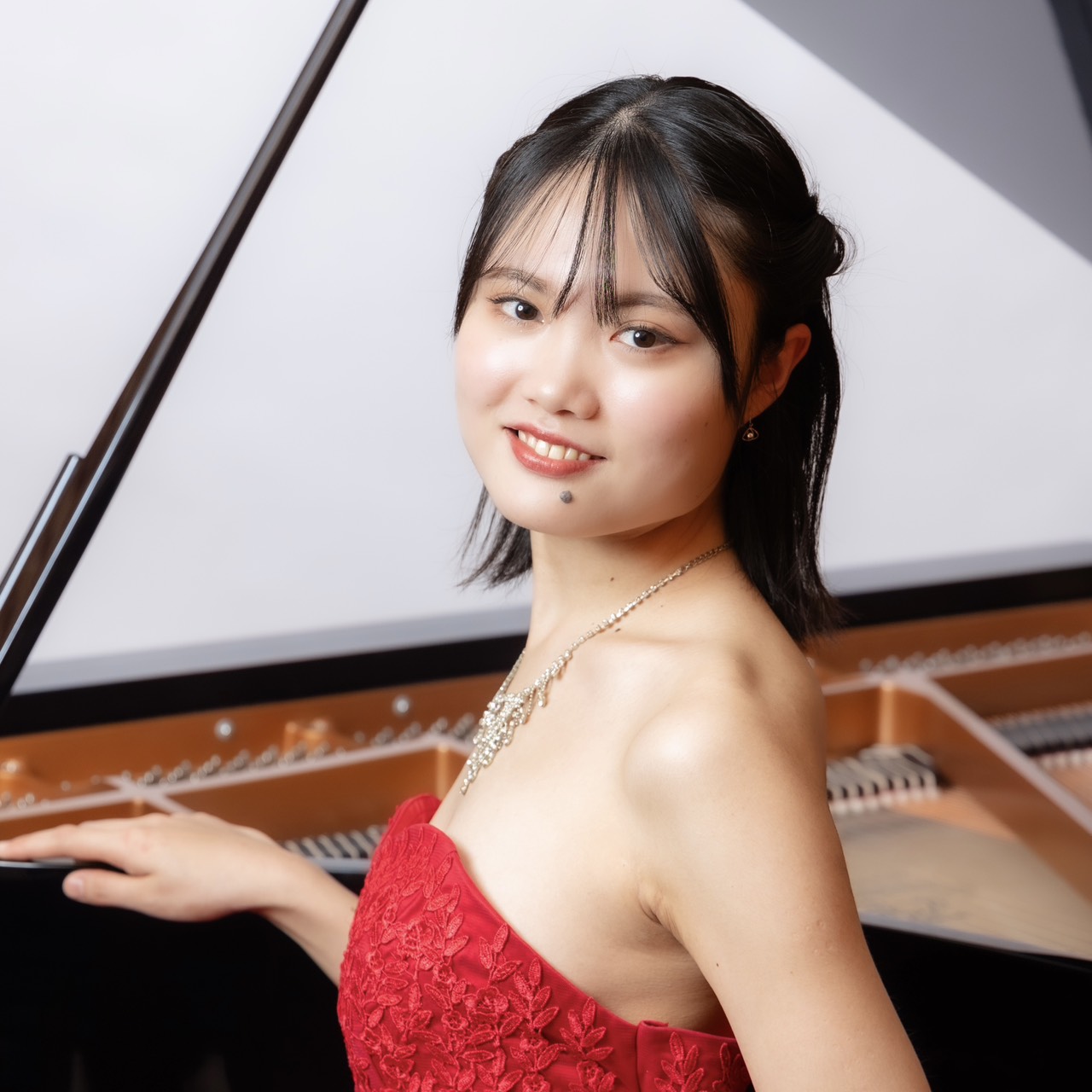 ピアノを背景にしたNAYUTAS一宮校の講師